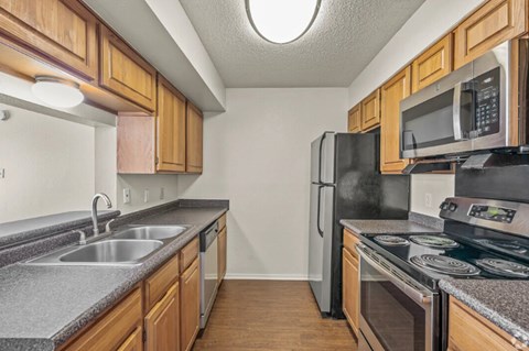 A kitchen with wooden cabinets and black appliances.