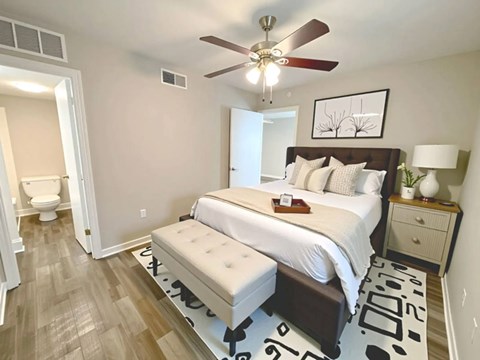 A bedroom with a large bed and a ceiling fan.