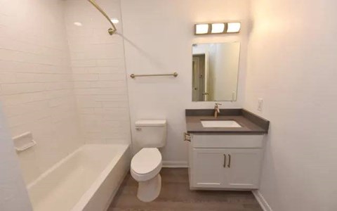A white bathroom with a toilet, sink, and bathtub.