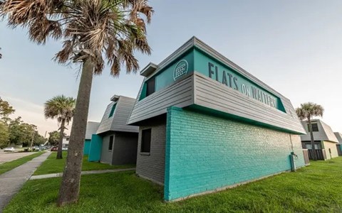 A building with a green roof and a sign that says Flats on Water.