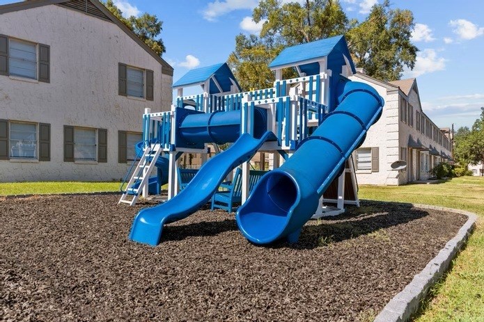 A blue playground slide in front of a building.