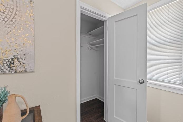 A white door is open to a small, empty room.