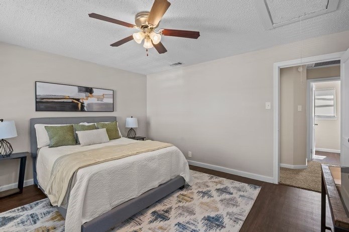 A bedroom with a bed, a ceiling fan, and a rug.