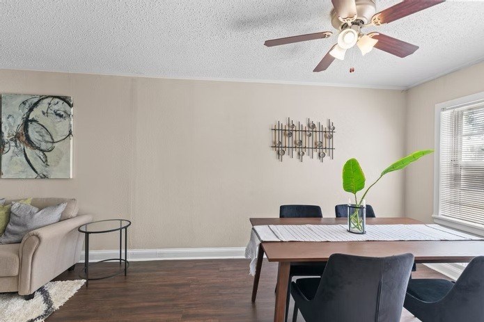 A living room with a couch, chairs, and a table with a plant on it.