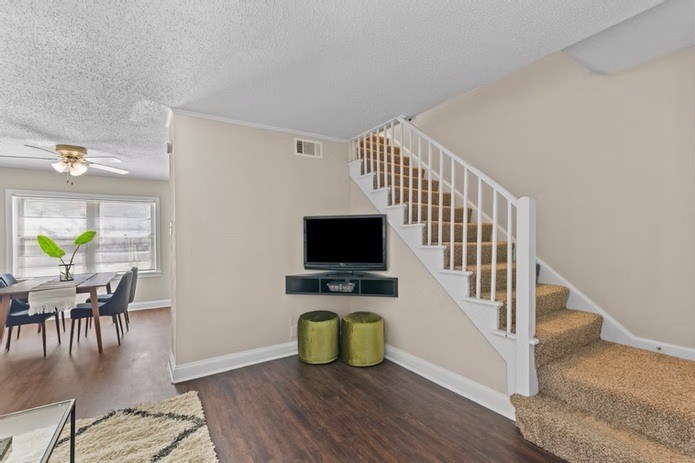 A living room with a staircase leading to the second floor.