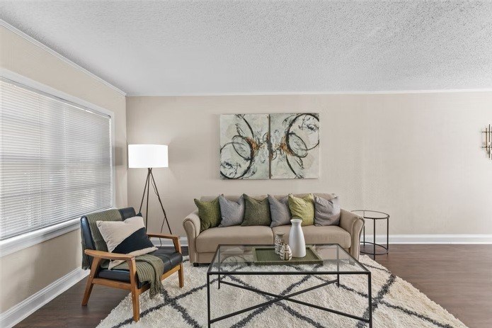 A living room with a couch, chair, and a painting on the wall.