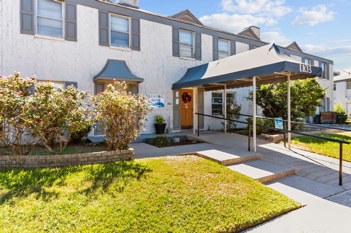 A building with a blue awning and a sign that reads "LIQUOR".