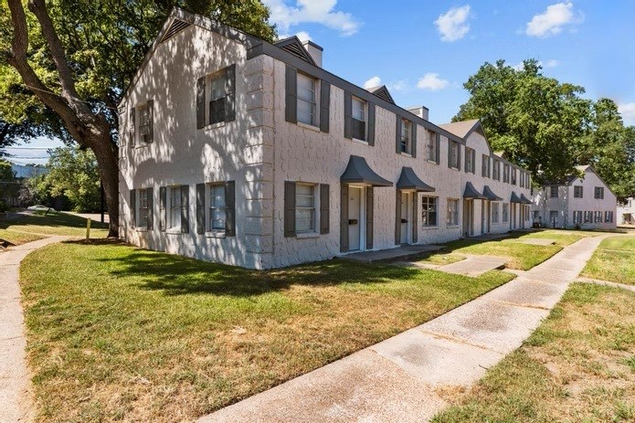 A long building with a lot of windows and a tree in front of it.