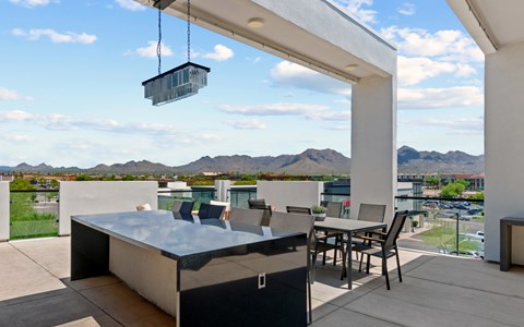 A modern outdoor kitchen with a hot tub and a view of the mountains.
