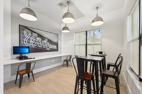 A modern dining room with a chalkboard on the wall and a TV on the left side.