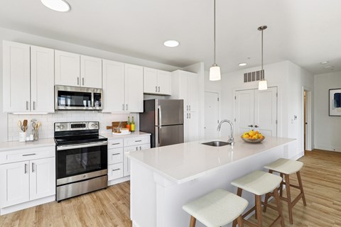 A modern kitchen with white cabinets and a large island.