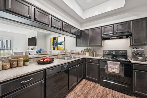A kitchen with dark wood cabinets and a black stove top oven.