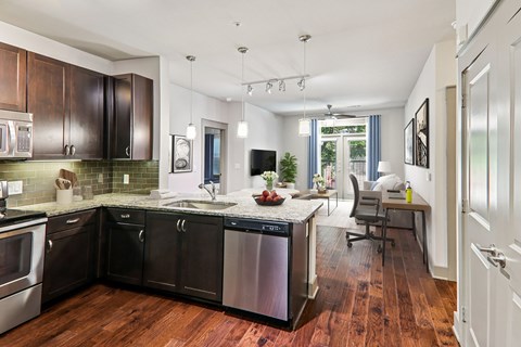 A kitchen with dark wood cabinets and a white counter top.