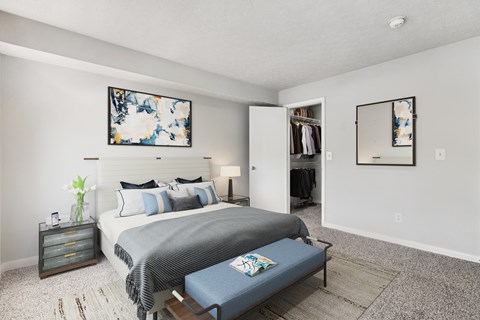 A bedroom with a bed, nightstand, and a painting on the wall.