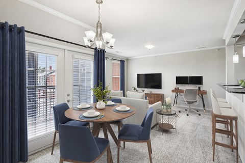 A dining room with a round table and blue chairs.