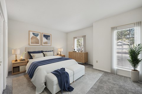A bedroom with a large bed and a plant.