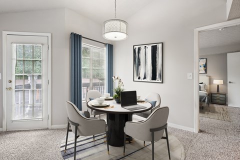 A dining room with a round table and chairs.