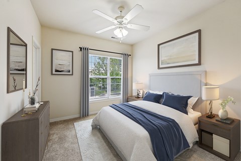 A bedroom with a bed, nightstands, and pictures on the wall.