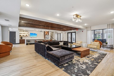 A modern living room with a black couch and wooden floors.