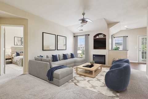 A living room with a grey couch, a coffee table, and a fireplace.