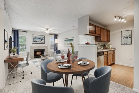 A modern dining room with a table set for two and a fireplace.