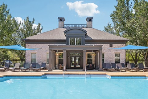 A house with a pool in front of it.