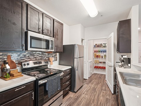 A kitchen with a black counter top and a stove top oven.