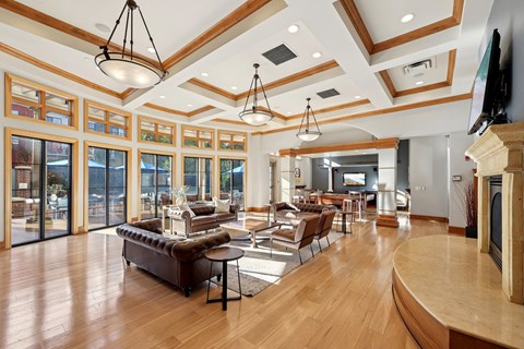 A living room with a brown leather couch and a wooden floor.