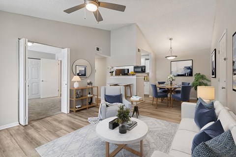 A living room with a white couch, a coffee table, and a ceiling fan.