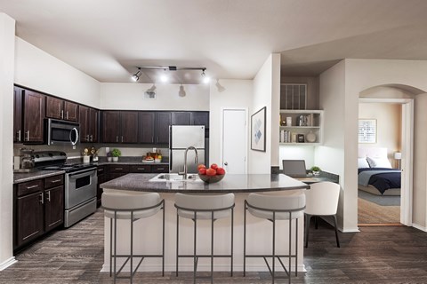 A kitchen with a bar stool in front of the island.