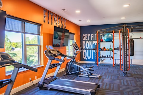 A gym with orange walls and a sign that says "Get fit, don't quit".