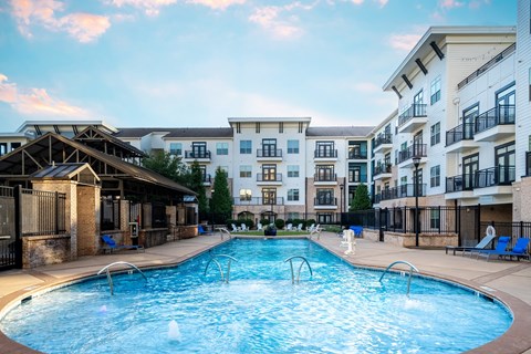 A large swimming pool in front of apartment buildings.