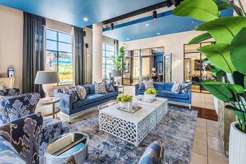 A living room with a blue couch and a white coffee table.