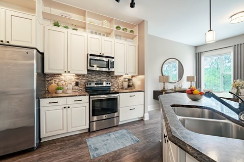 A modern kitchen with a stainless steel refrigerator and a microwave above the stove.