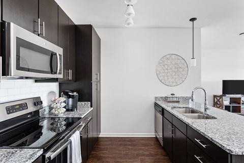 A modern kitchen with black cabinets and a white countertop.