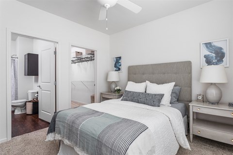 A bedroom with a large bed and a ceiling fan.