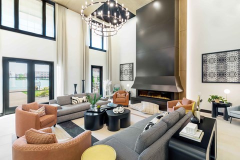 A modern living room with a grey sofa and a black chandelier.