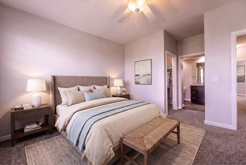 A bedroom with a large bed and a bench.