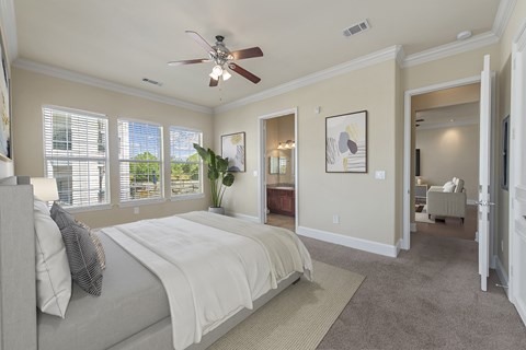A bedroom with a large bed and a ceiling fan.
