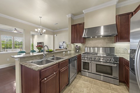 A modern kitchen with dark wood cabinets and stainless steel appliances.