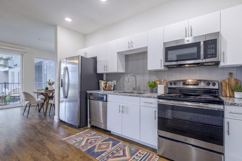 A modern kitchen with stainless steel appliances and white cabinets.