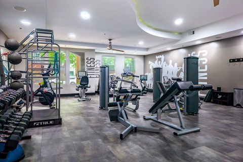 A gym with a variety of equipment including weights and machines.