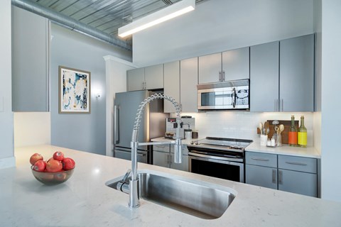 A modern kitchen with a stainless steel sink and refrigerator.