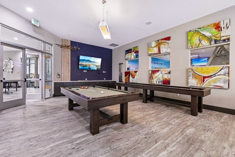 A room with a pool table and a TV mounted on the wall.