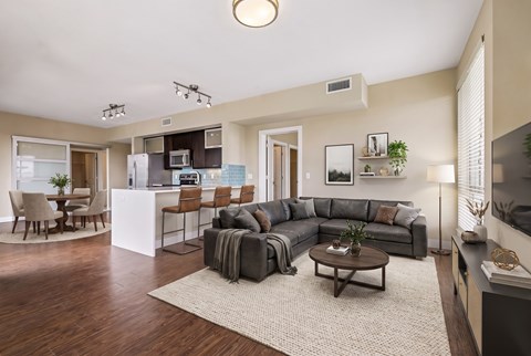 A modern living room with a grey sofa set and a wooden coffee table.