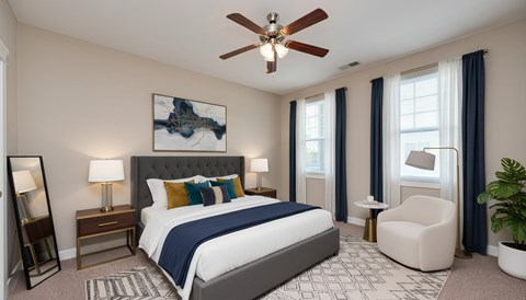 A bedroom with a large bed, a ceiling fan, and a painting on the wall.
