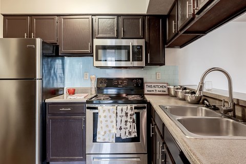 A kitchen with a stove top oven and a refrigerator.