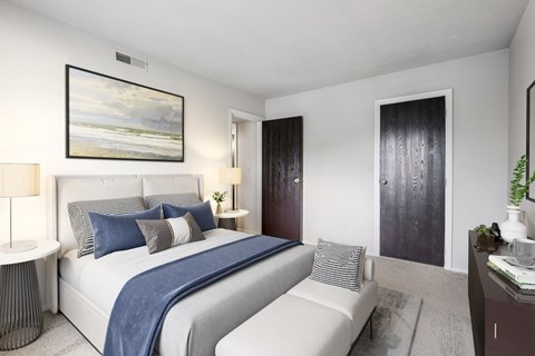 A bedroom with a large bed and a painting on the wall.