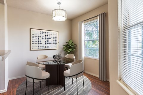 A dining room with a table and chairs.