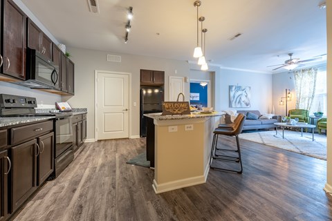 A kitchen with dark wood cabinets and a white island.